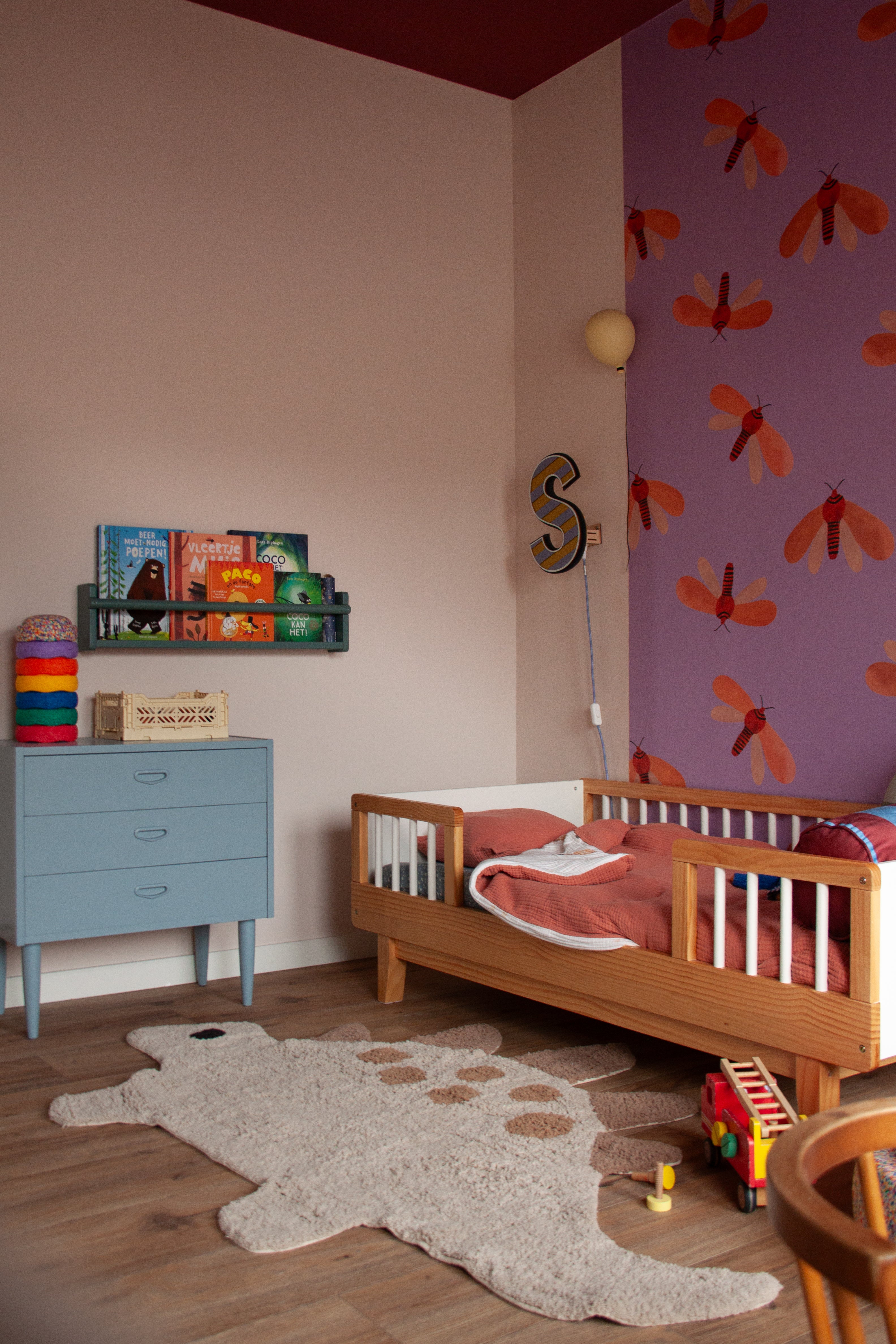 Modern kinderkleed met dino print in rustige, natuurlijke kleuren.