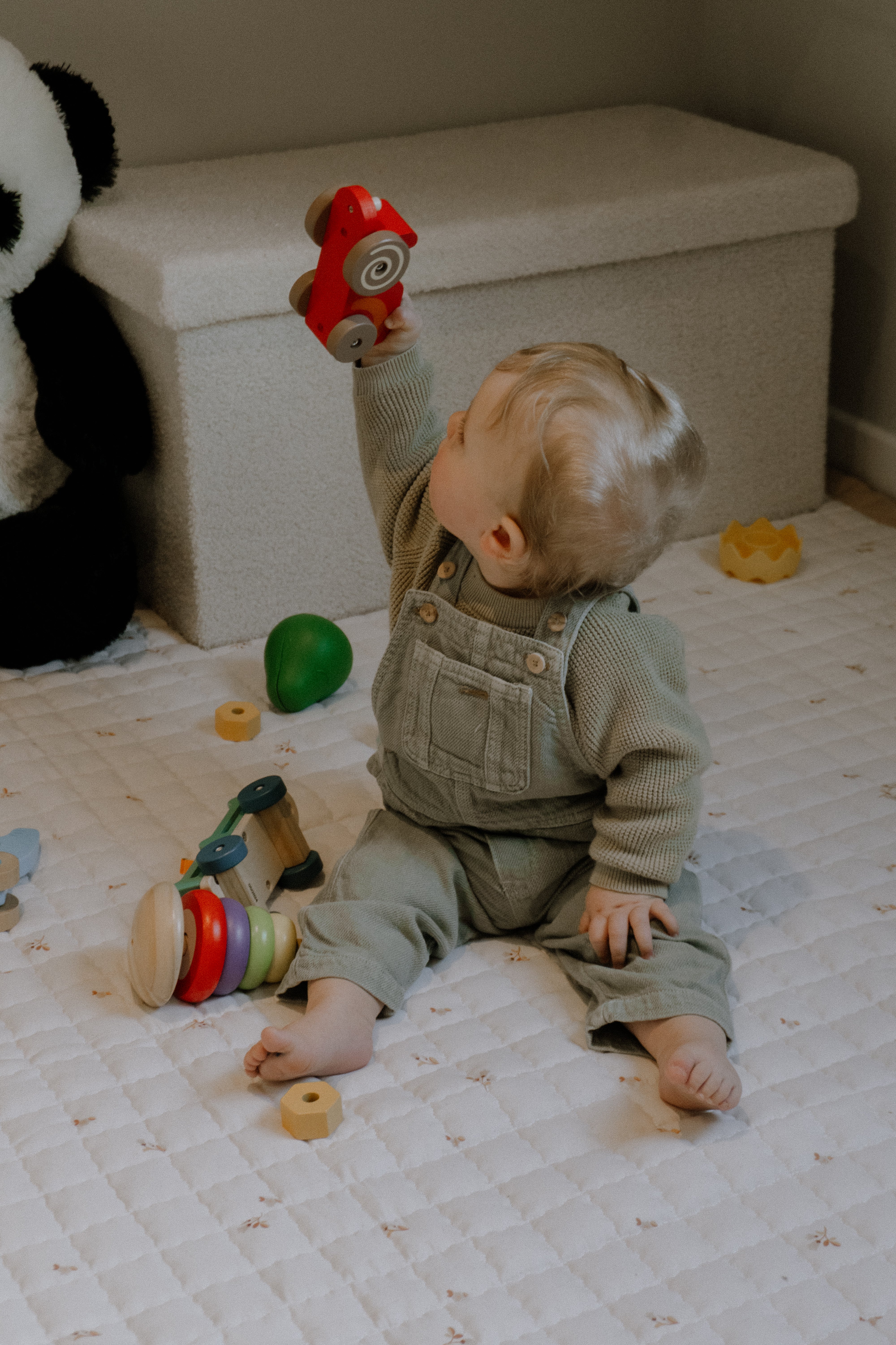 Zacht speelkleed met een lichte achtergrond vol stippen en bloemetjes – helder en warm.