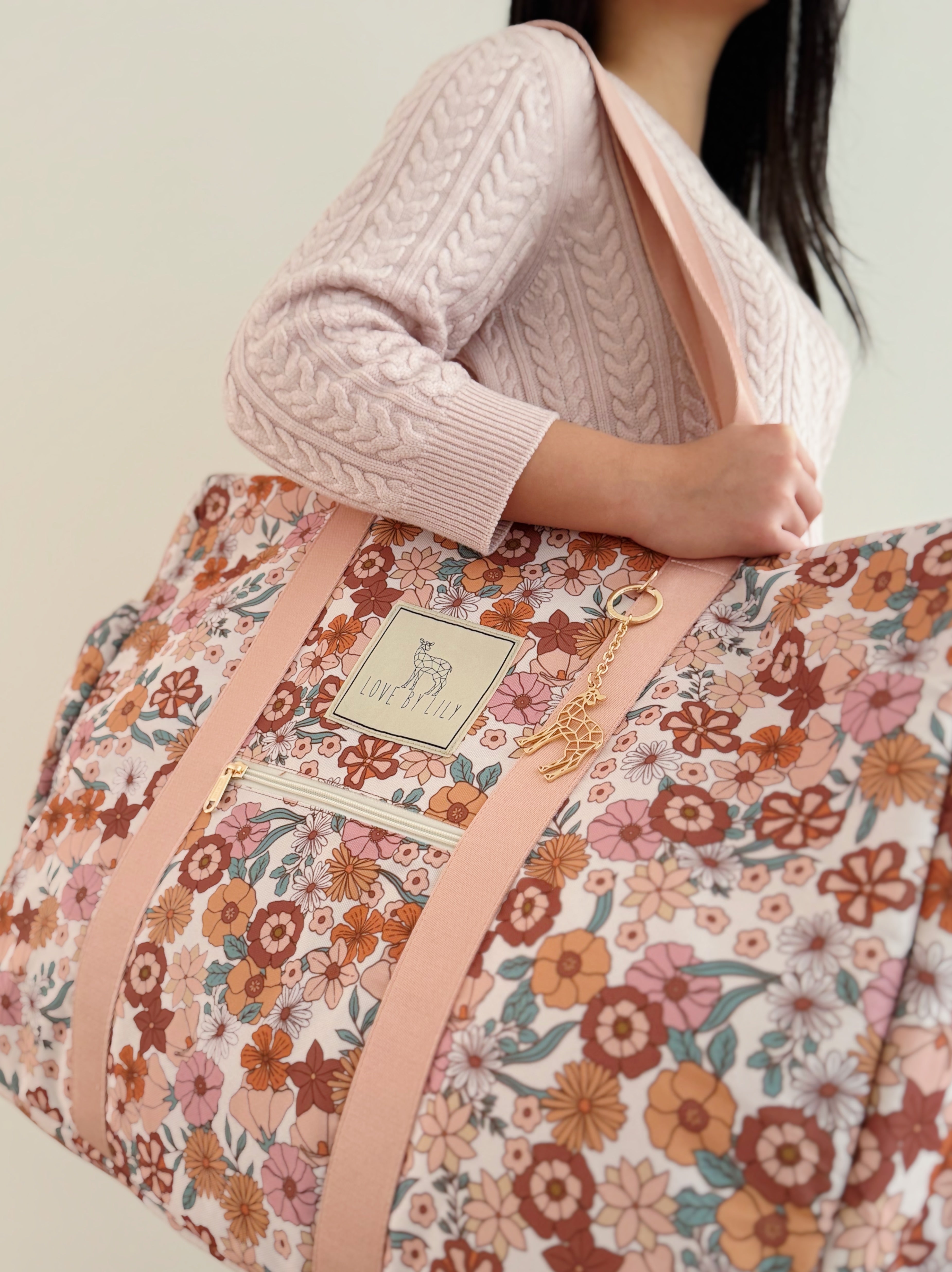 Moeder met Travel Mom Bag Flowerfarm – stijlvolle luiertas met bloemenprint.