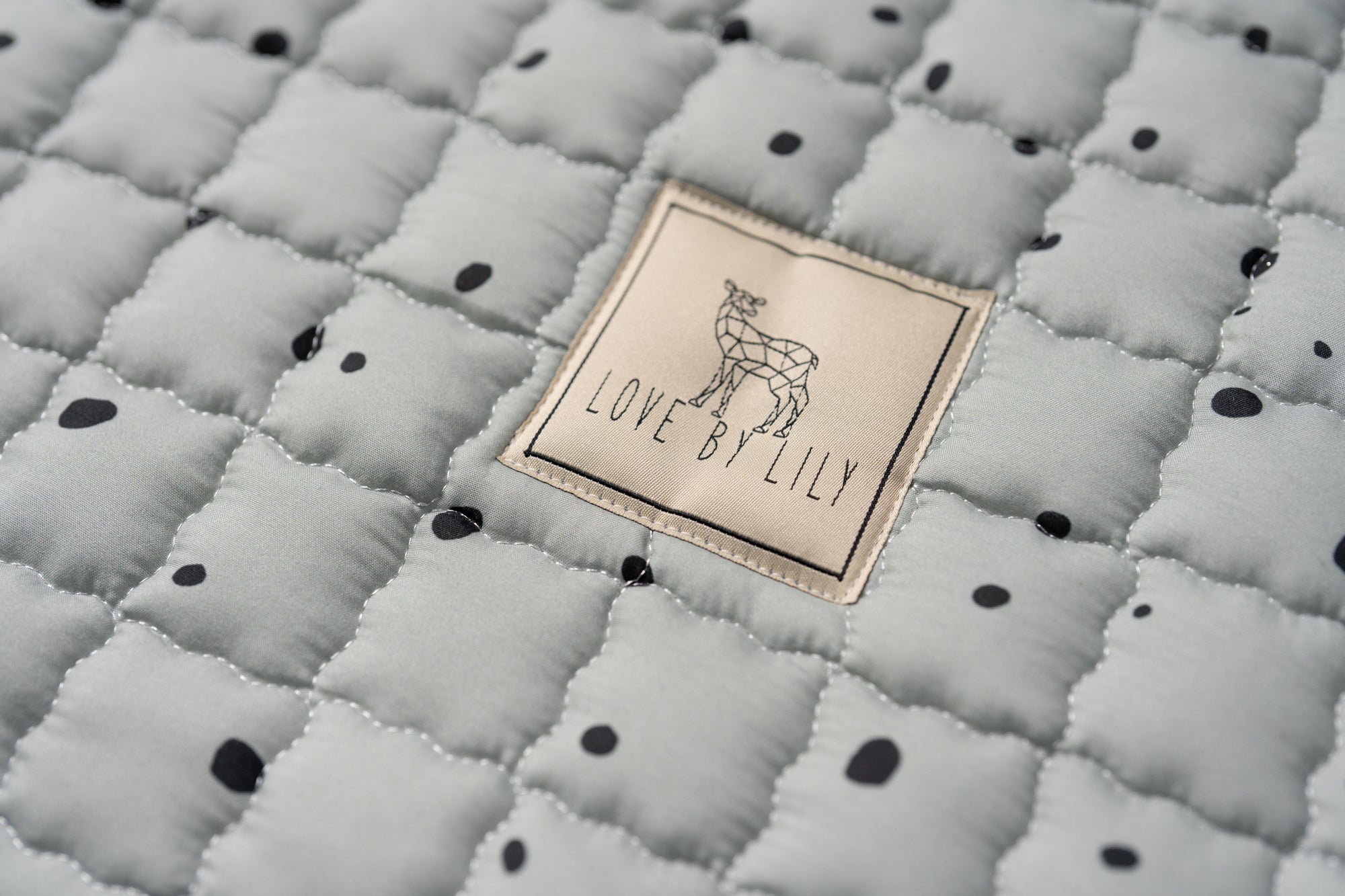 Natuurlijk patroon van zwarte vlekken op een warme groentoon – minimalistisch & speels.