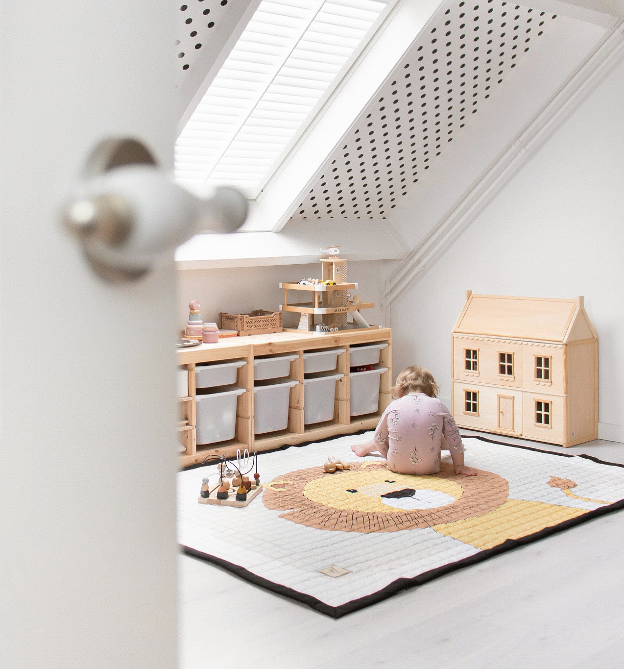 Een vriendelijk brullende leeuw op een rustgevend speelkleed – ideaal voor knusse speelmomenten.