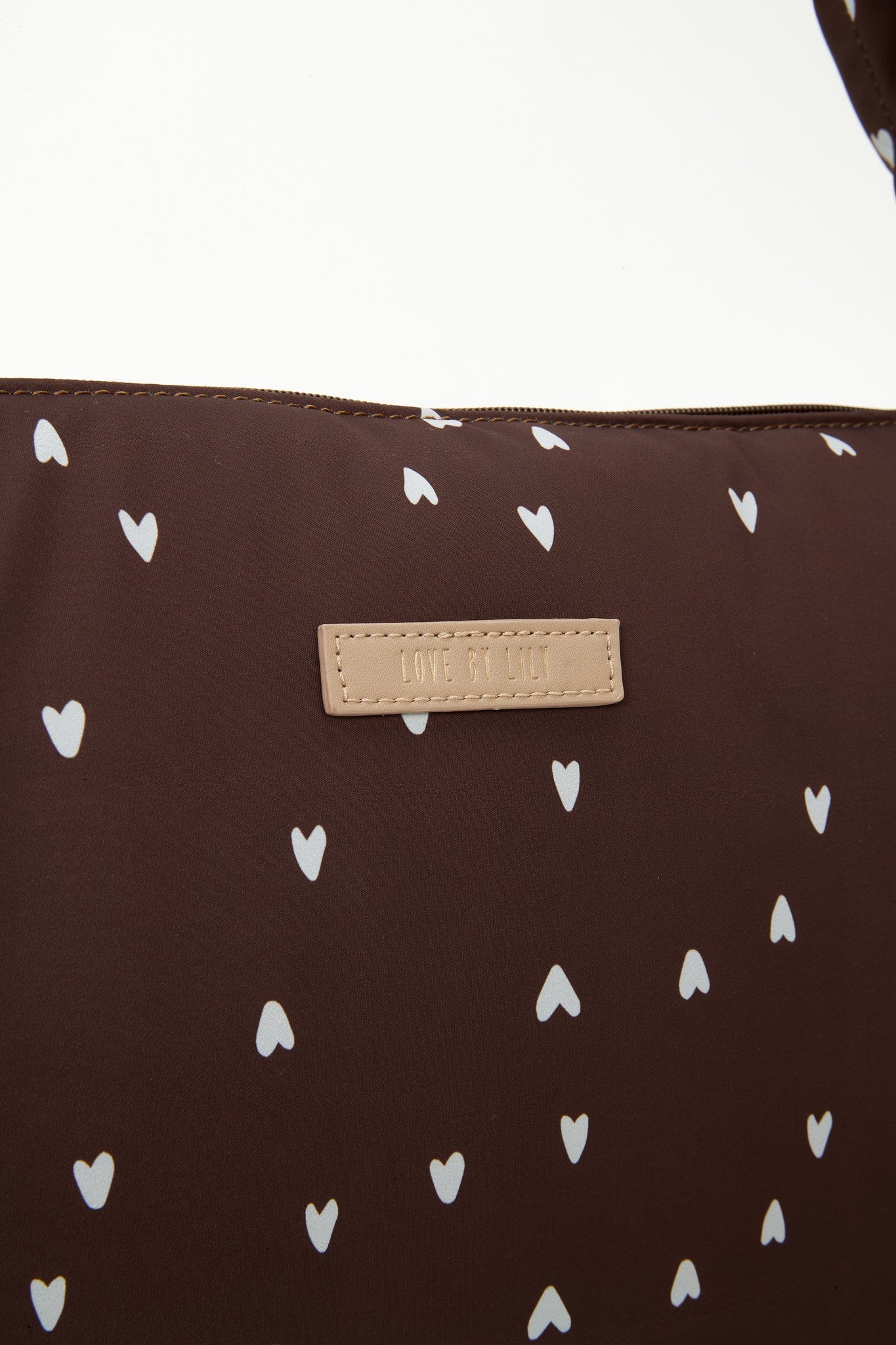The Lily Tote luiertas van Love by Lily in Deep Amour hartjesprint, close-up van het Love by Lily-labelpatch