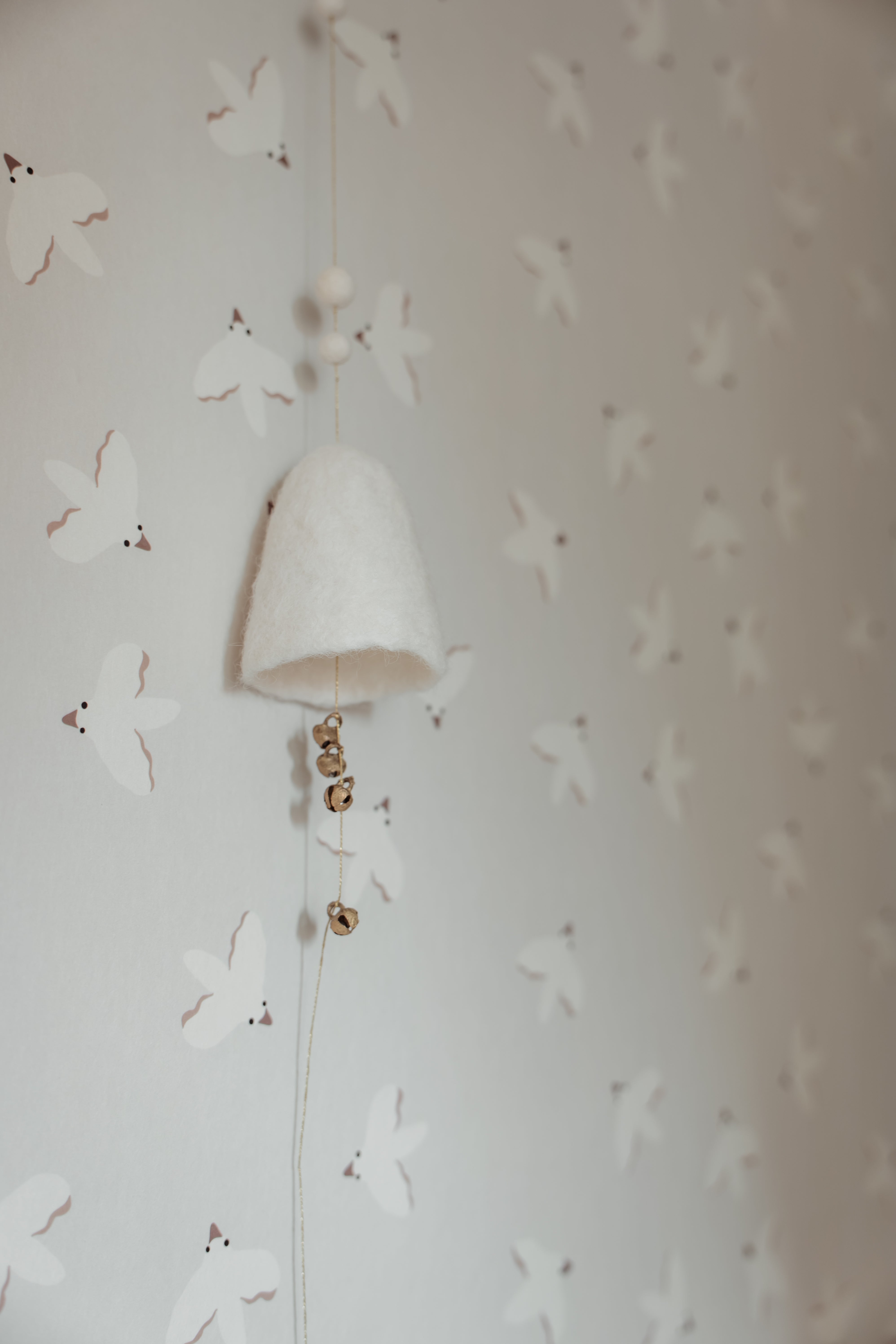 Neutraal beige behang met subtiele vogels. Dankzij het handgetekende design past dit unisex behang in elke kinderkamer, babykamer of speelhoek.