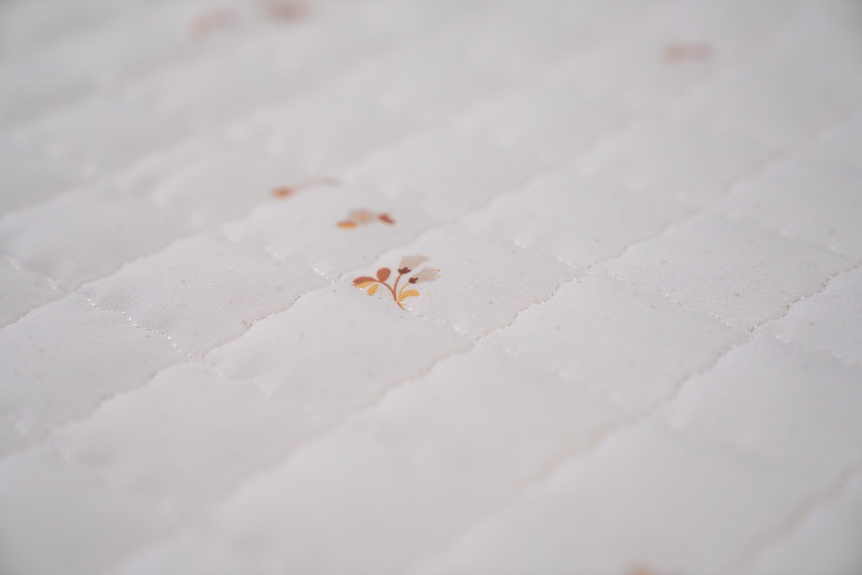 Speelkleed met zachte bloemetjes en stipjes – een speelse en lieve ondergrond.