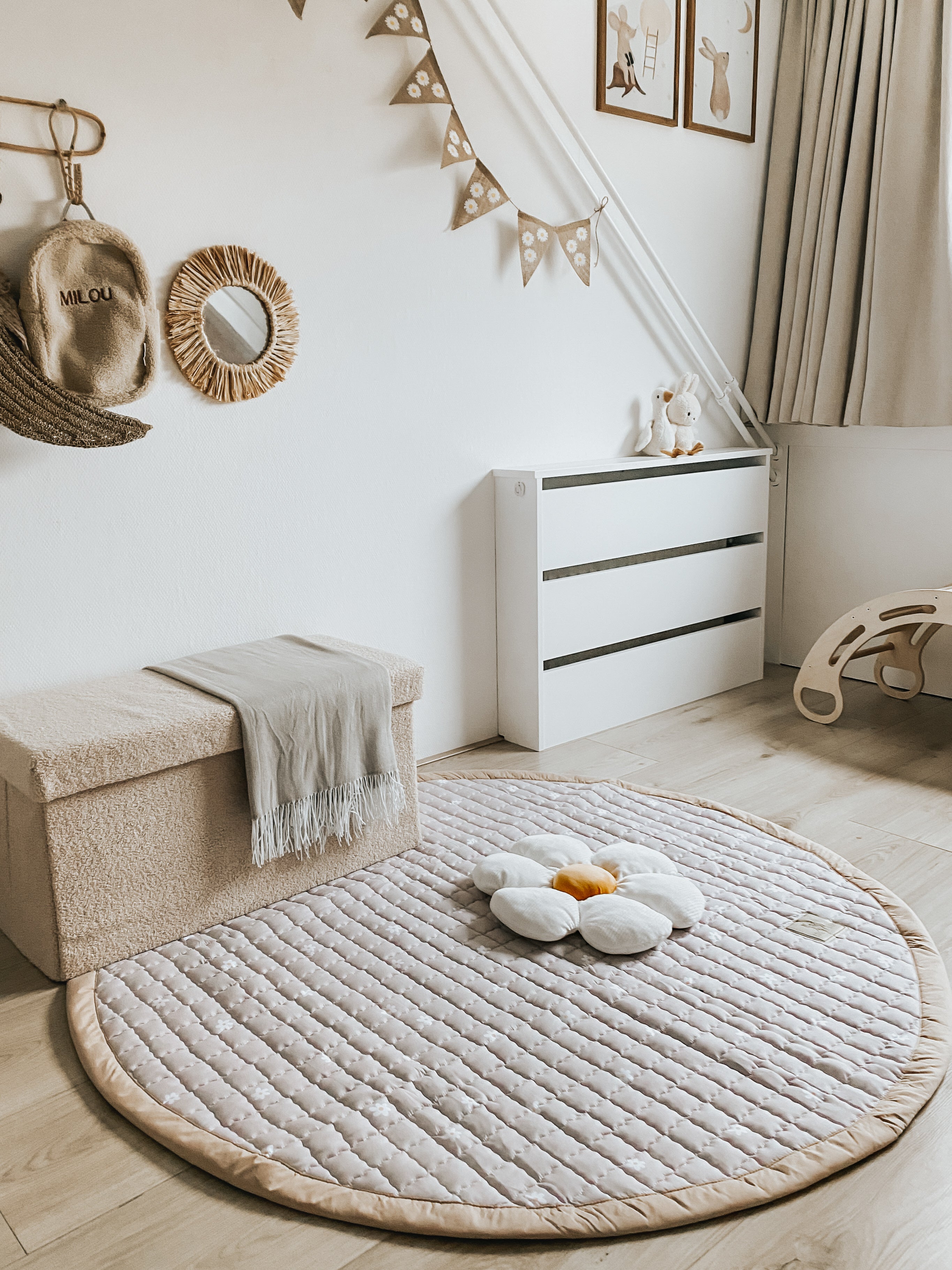 Minimalistisch rond speelkleed Daisies met rustige bloemetjesprint.
