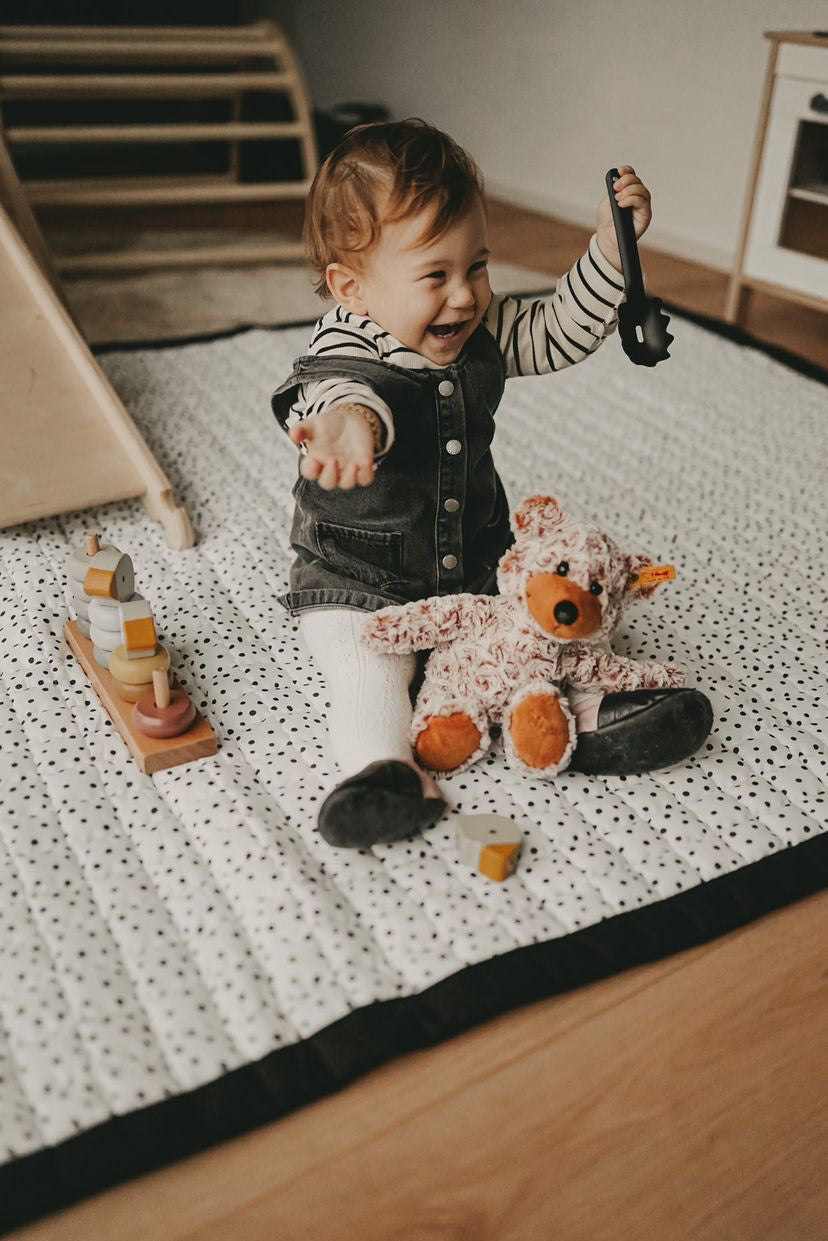 Een speels zwart-wit speelkleed met stippen – voor eindeloos speelplezier.