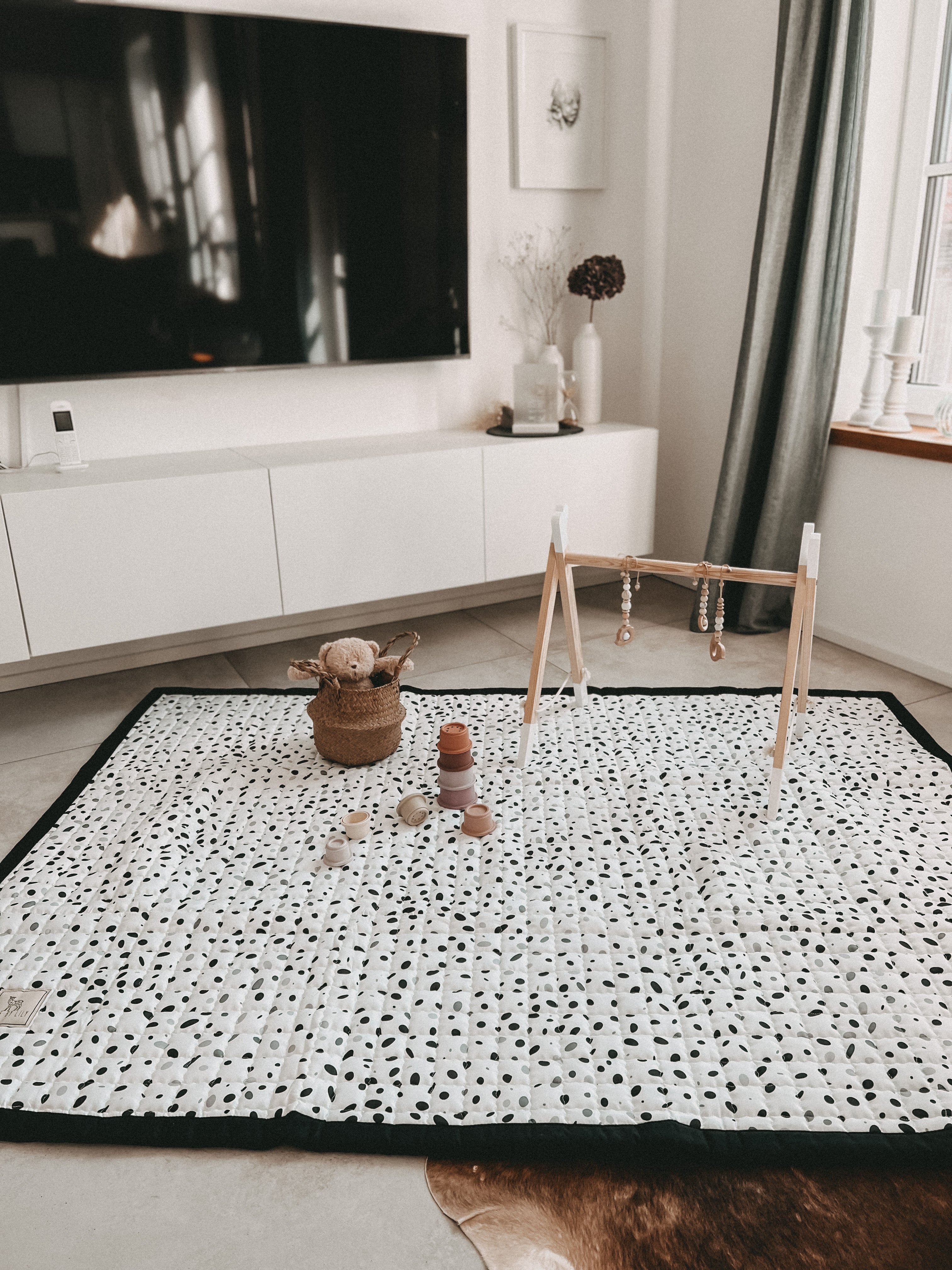 Speelkleed met speelse ‘kiezels’ op een witte ondergrond – minimalistisch en multifunctioneel.