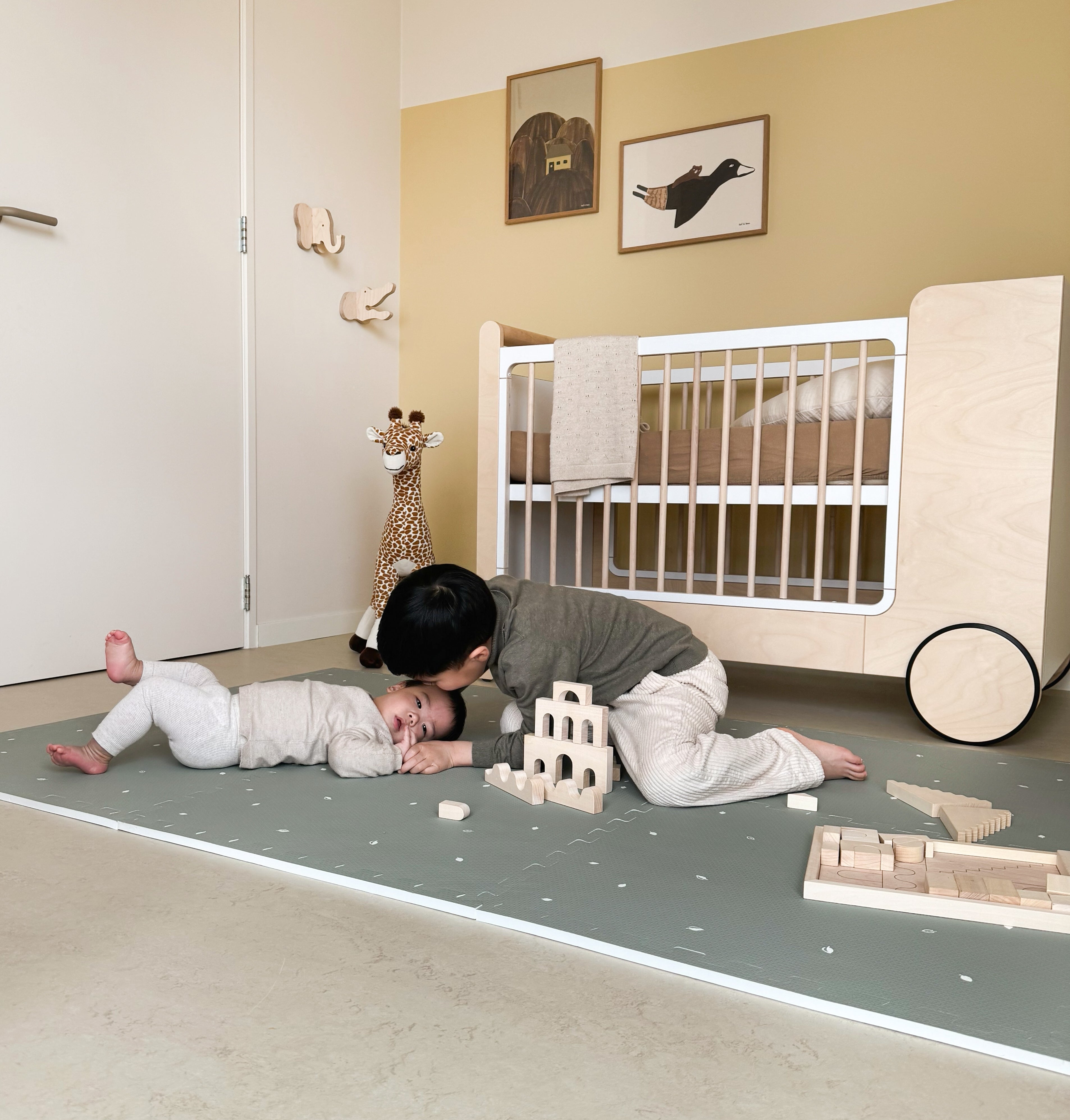 Kind spelend op Olive Sage puzzelmat, rustig botanisch patroon in zachte groentinten