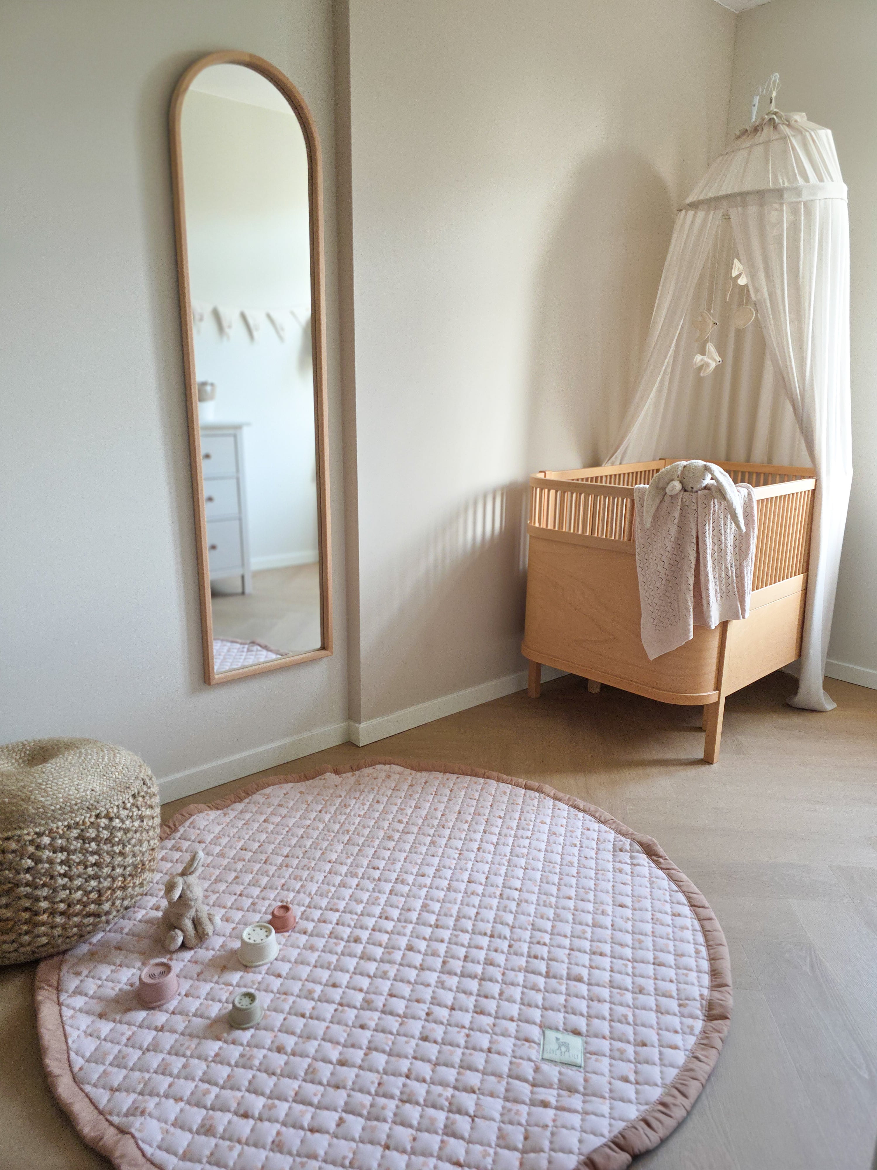 Rond speelkleed Sandy Clovers stijlvol geplaatst in een babykamer.