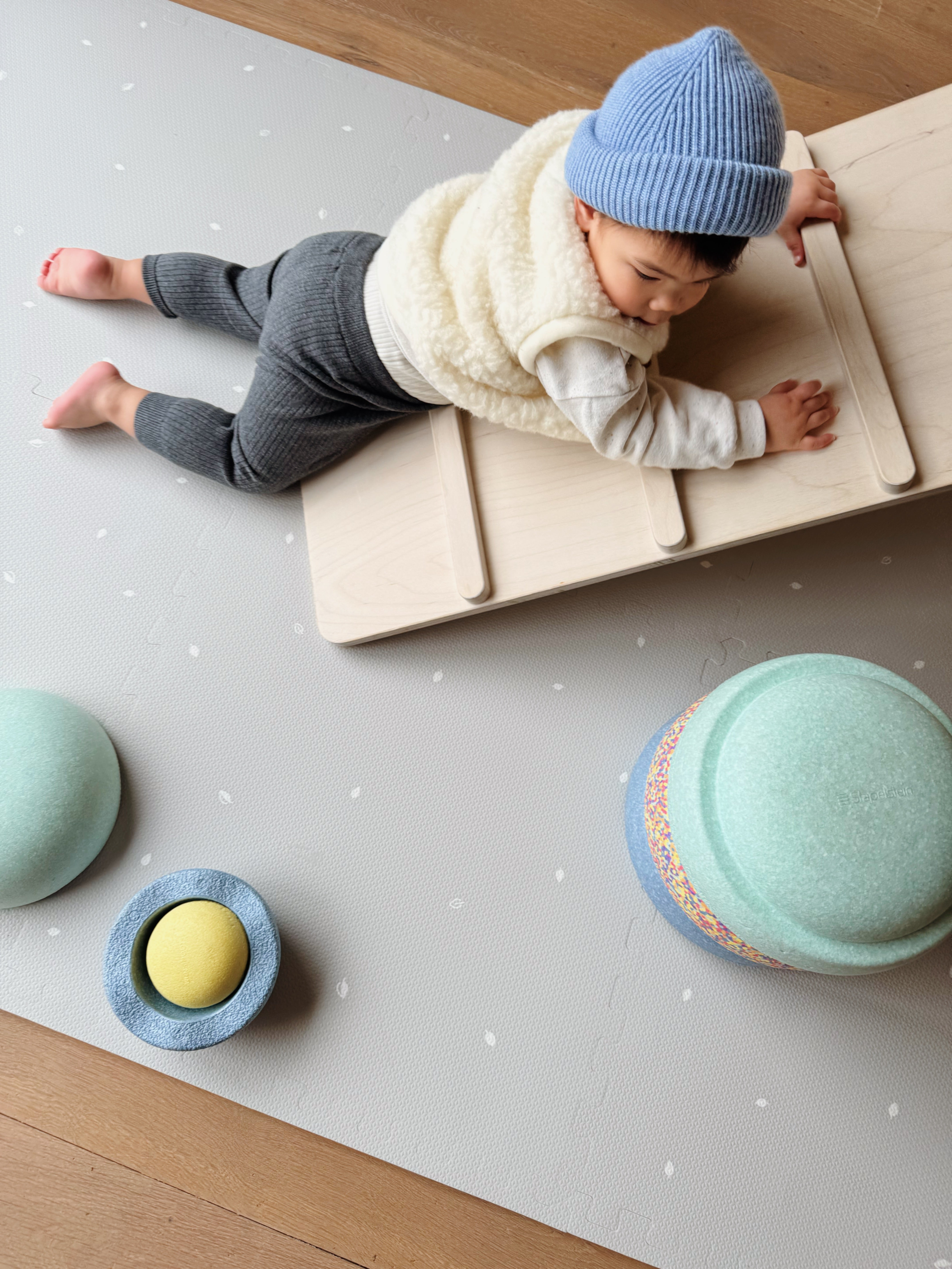 Baby spelend op Arctic Grey puzzelspeelmat – unisex design in grijstinten