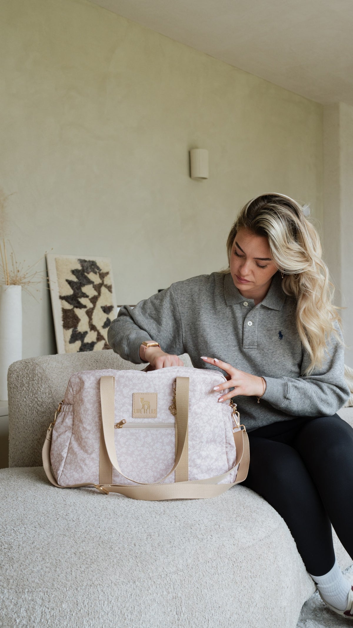 Vrouw op de bank met een luiertas met bloemenprint van Love by Lily