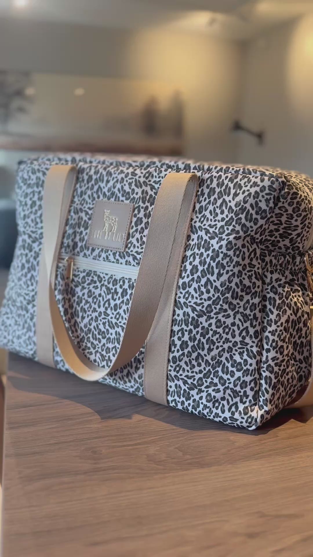 Een stijlvolle luiertas met een licht luipaardpatroon – rustig en modern.
