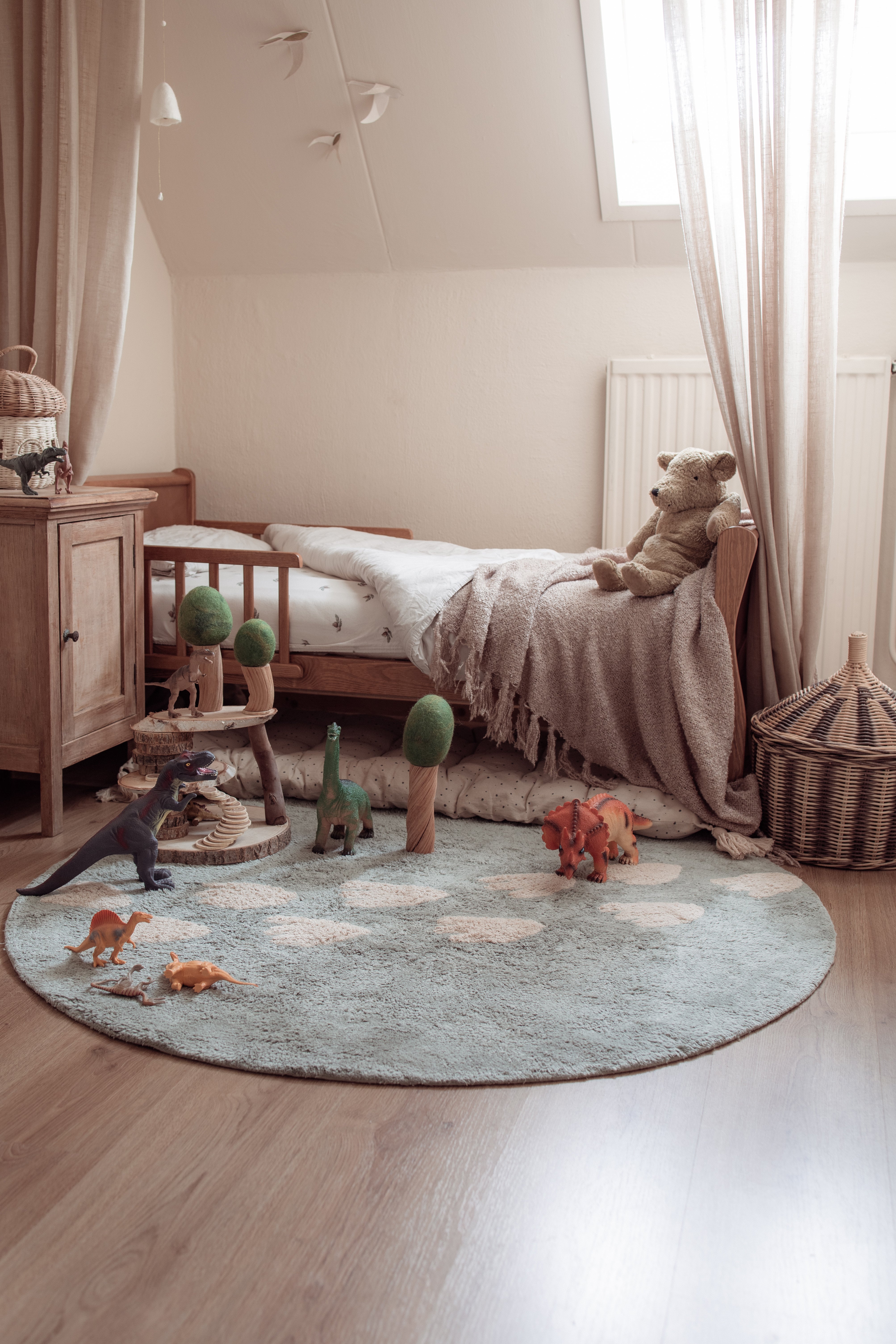 Neutraal dino vloerkleed in ronde vorm, geschikt voor babykamer