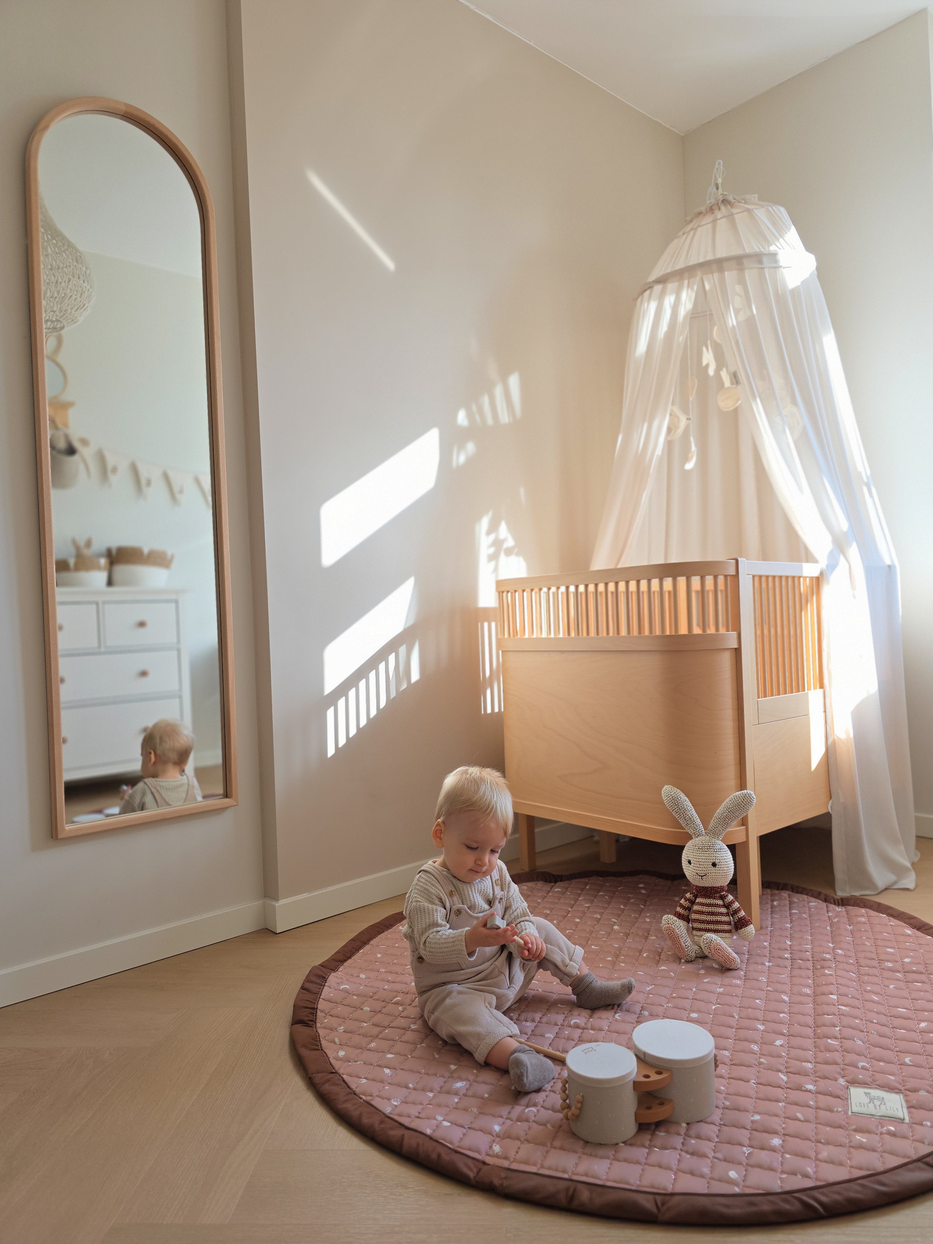Neutraal rond speelkleed met planeten en sterren voor de babykamer.
